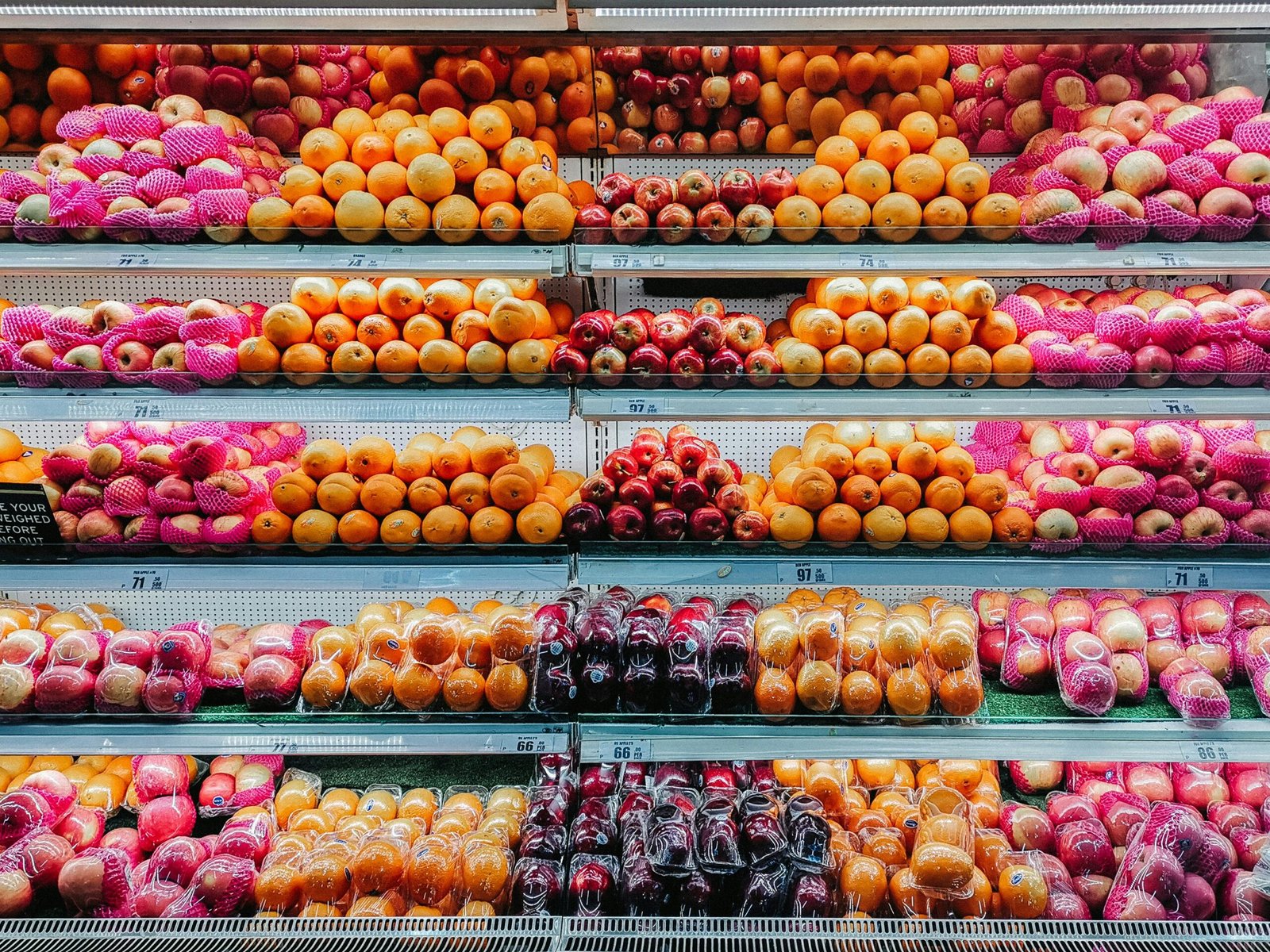 Colorful variety of fresh fruits neatly arranged on supermarket shelves, showcasing abundance and freshness.